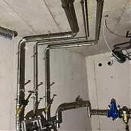 Öskü városában, a HydroArt Kft. Épületgépészet szakterületén készült fotón látható egy modern vízvezeték-rendszer, amely rozsdamentes acél csövekből áll. A csövek szakszerűen vannak elhelyezve, és különböző szelepekkel és csatlakozókkal vannak ellátva, amelyek a hatékony vízkezelést segítik elő. A háttérben a fal szerkezete is látható, ami a munka precizitását tükrözi.